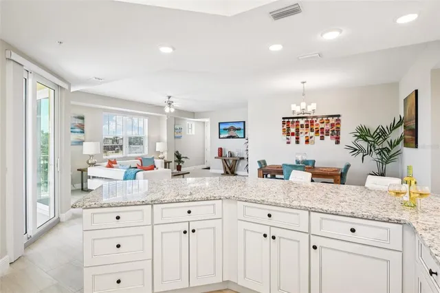 a kitchen with granite countertop white cabinets and white stainless steel appliances