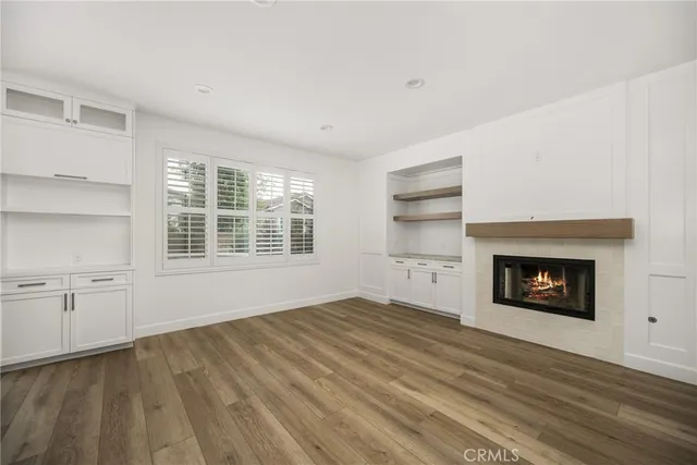 a view of an empty room with a fireplace and a window