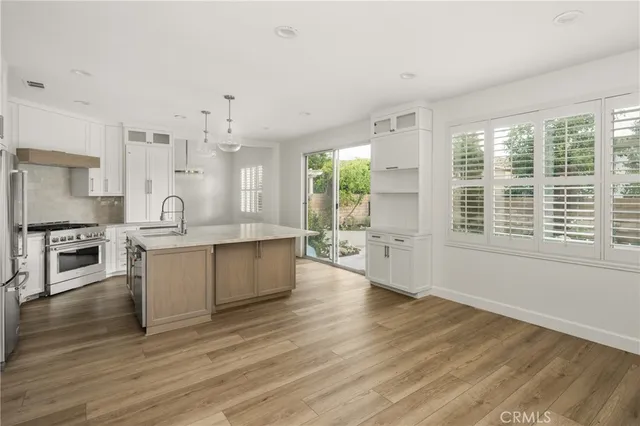 a large kitchen with granite countertop a large counter top space a sink stainless steel appliances and cabinets