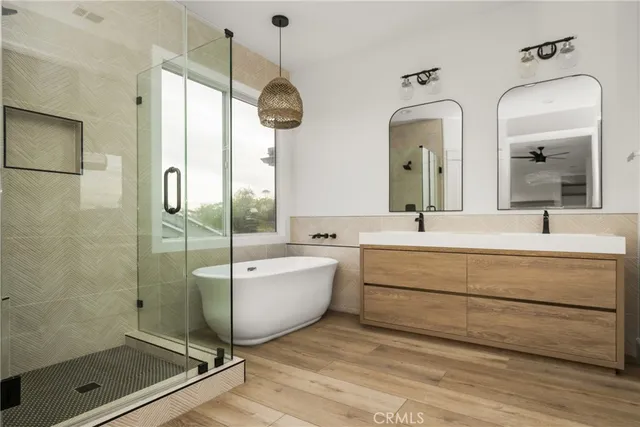 a bathroom with a double vanity sink mirror and bathtub