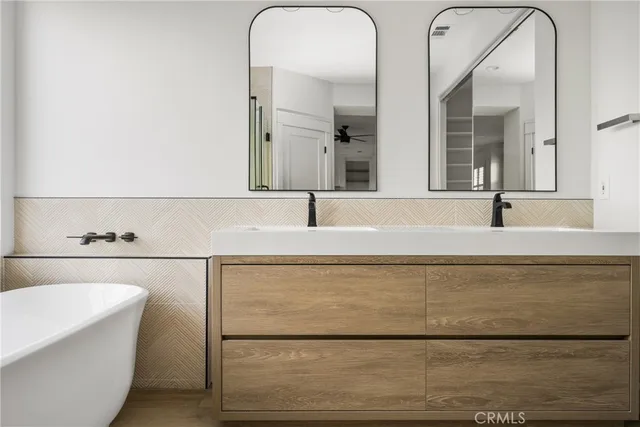 a bathroom with double vanity sink and a bathtub