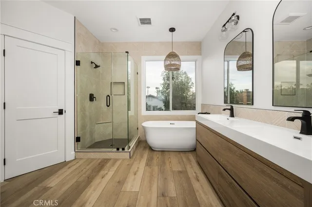 a large spacious bathroom with a double vanity sink a large mirror and a bathtub