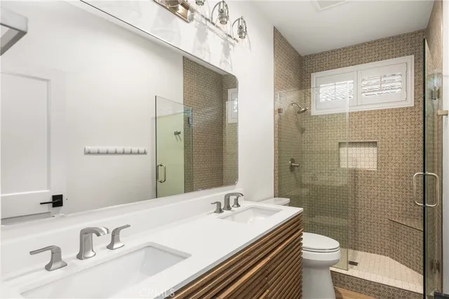 a bathroom with a granite countertop sink toilet a large mirror and shower