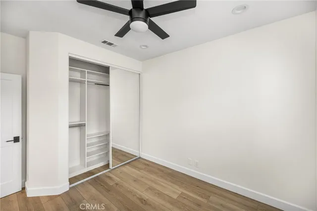 an empty room with wooden floor and closet