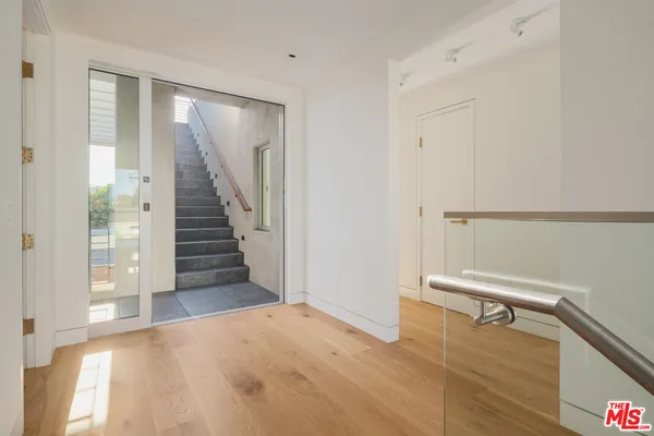 a view of entryway and hall with wooden floor