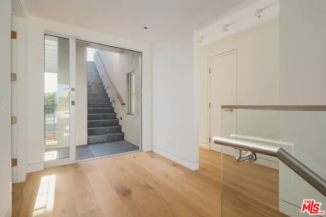 a view of entryway and hall with wooden floor