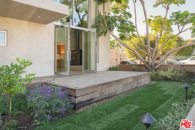 a green field with flowers and trees