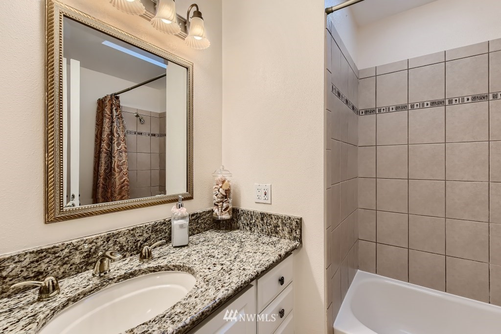 32219 22nd Avenue Southwest Federal Way, WA 98023 - Photo 31 of 36 a bathroom with a granite countertop sink vanity mirror and bathtub