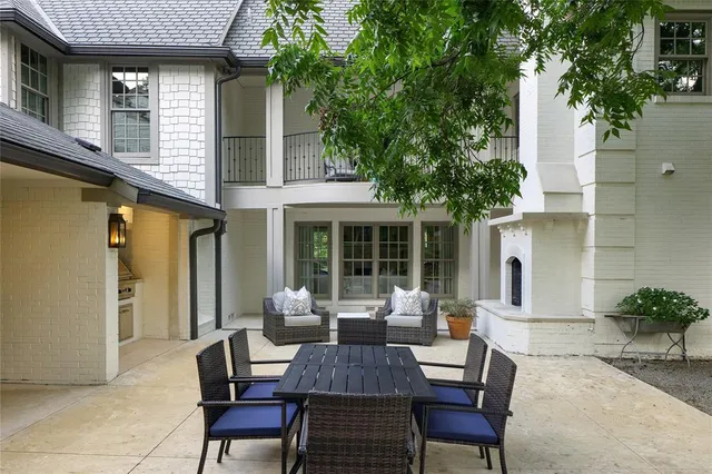 a view of a patio with table and chairs and a large tree