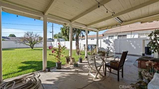 a view of a patio with table and chairs potted plants and palm tree