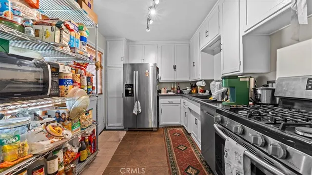 a kitchen with stainless steel appliances granite countertop a refrigerator and a stove