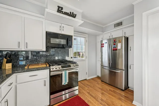 a kitchen with stainless steel appliances granite countertop a refrigerator stove and sink