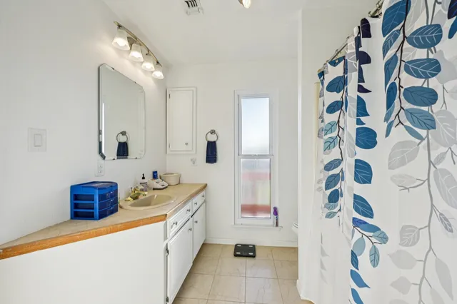 a spacious bathroom with a double vanity sink a mirror a bathtub and a shower