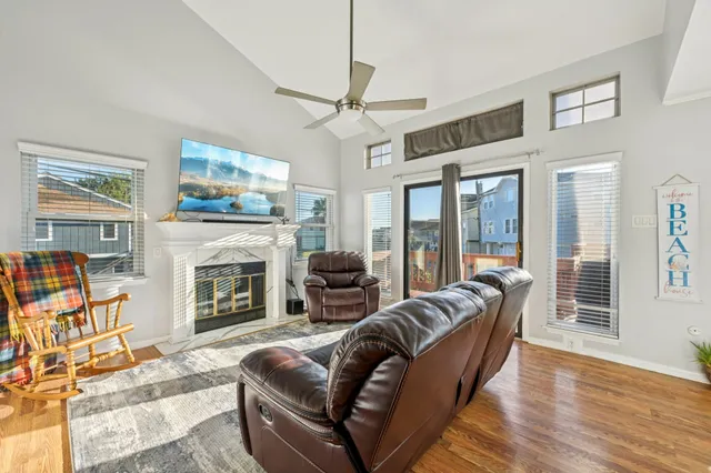 a living room with furniture a flat screen tv and a fireplace