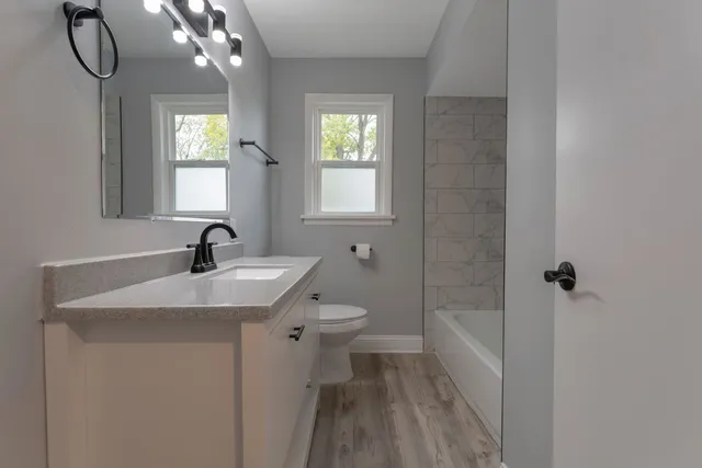 a bathroom with a sink a toilet and shower