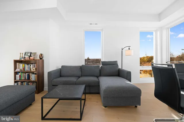 a living room with furniture a rug and a book shelf