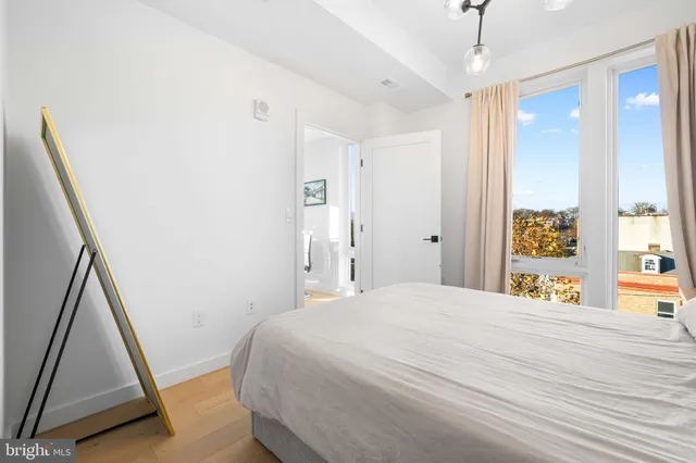 a bedroom with a bed and a flat tv screen on the dresser