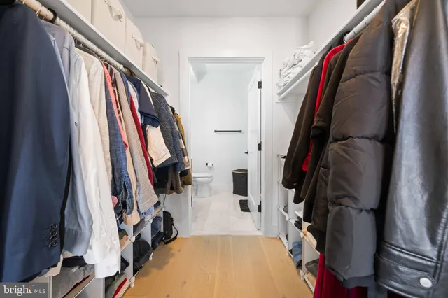 a view of walk in closet with clothes and shoes