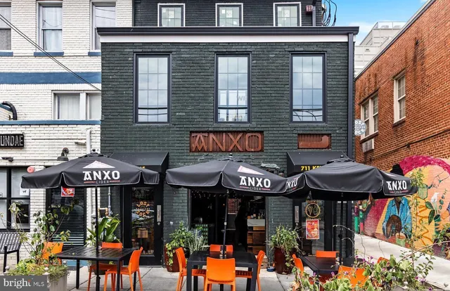 a view of a store with a lot of people seating on a patio