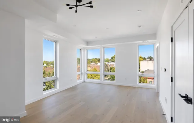 an empty room with windows and wooden floor
