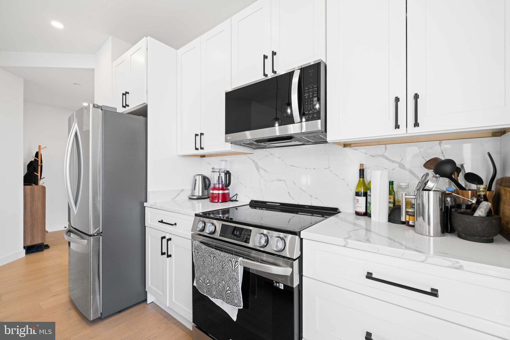 30 Kennedy Street Northwest, Unit 14 Washington, DC 20011 - Photo 10 of 40 a kitchen with stainless steel appliances white cabinets and a stove