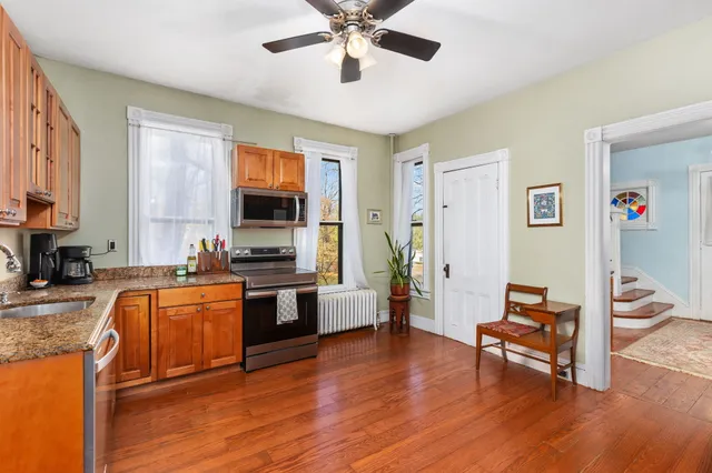 a kitchen with stainless steel appliances granite countertop a refrigerator stove top oven and cabinets