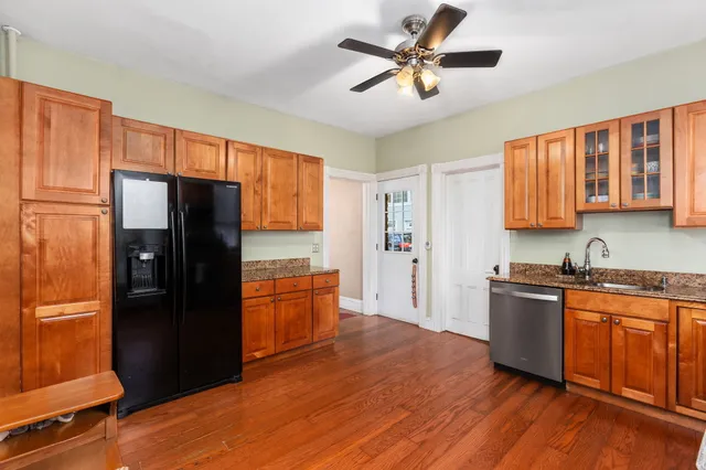 a kitchen with stainless steel appliances granite countertop a refrigerator a stove top oven a sink dishwasher and wooden cabinets