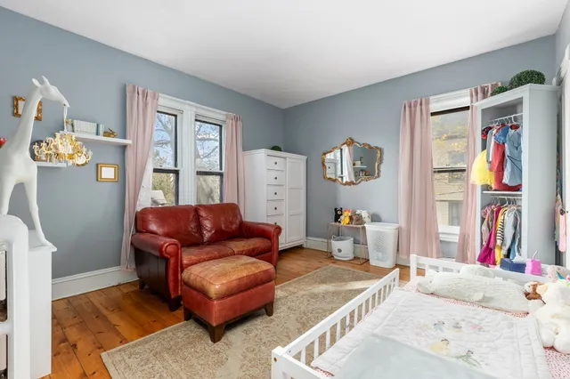a bedroom with furniture and a large window