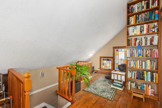 a bedroom with a bed a dresser and paintings on the wall