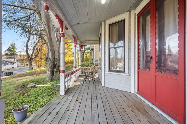 a view of a hallway to a livingroom with wooden floor and furniture