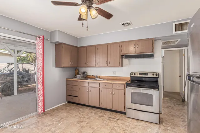 a kitchen with stainless steel appliances a stove a sink and a refrigerator