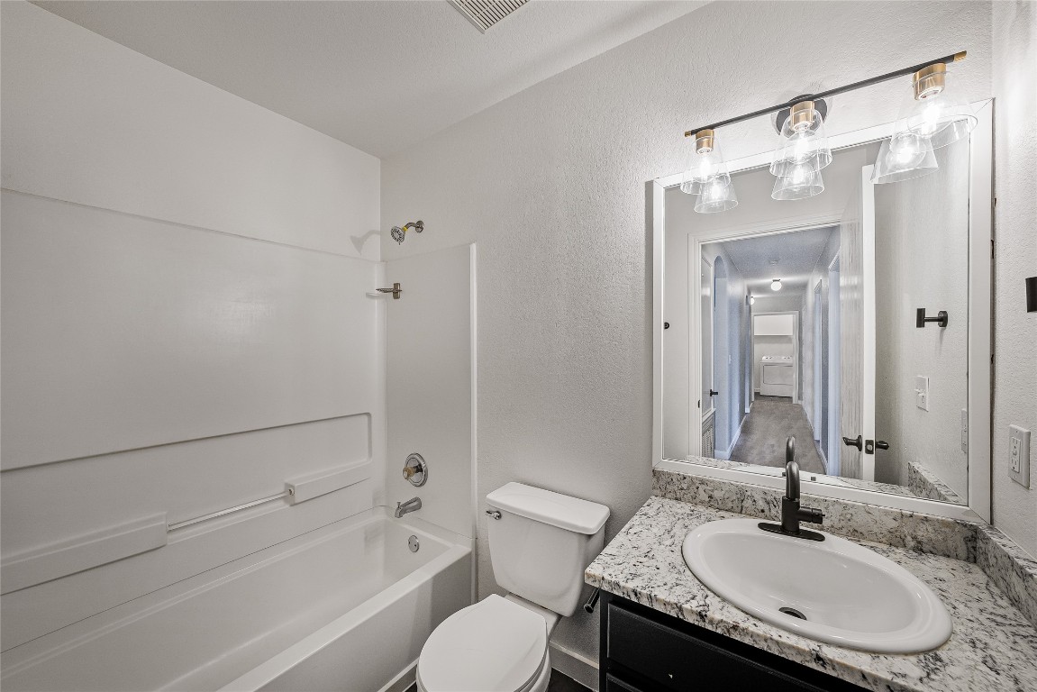 12517 Campana Drive Del Valle, TX 78617 - Photo 9 of 15 a bathroom with a granite countertop sink toilet and shower