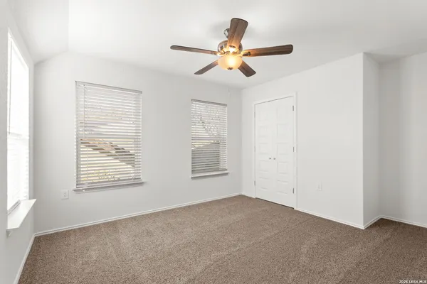 an empty room with a ceiling fan and a fan