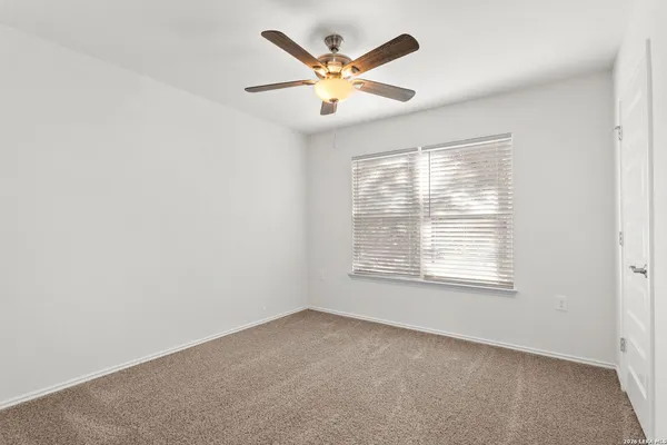 an empty room with closet and a chandelier fan