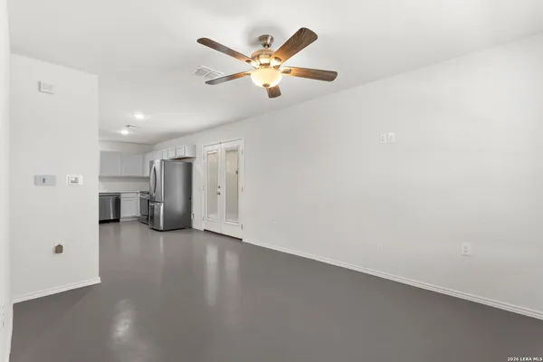 a view of a kitchen with refrigerator and white walls