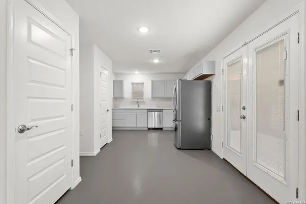a view of a kitchen with white cabinets