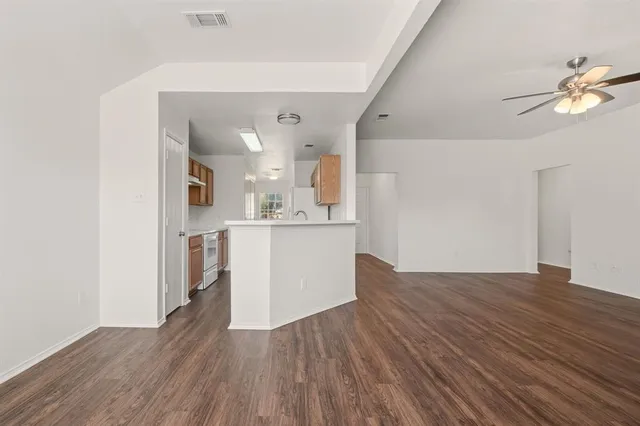 a view of a kitchen with wooden floor and a sink