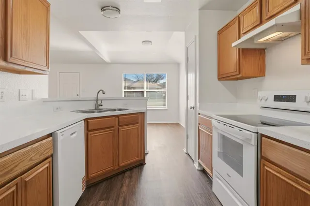 a kitchen with granite countertop a sink cabinets stainless steel appliances and a counter space