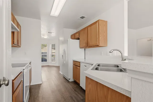 a kitchen with stainless steel appliances granite countertop a sink stove and wooden floor