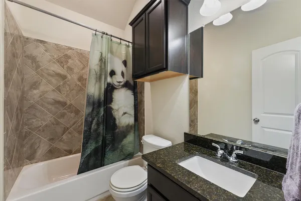 a bathroom with a granite countertop sink toilet and shower