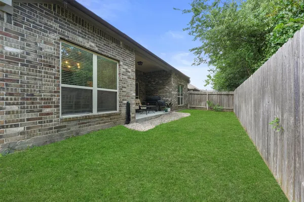 a view of a house with backyard and a tree