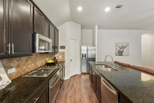 a kitchen with granite countertop a stove and a sink