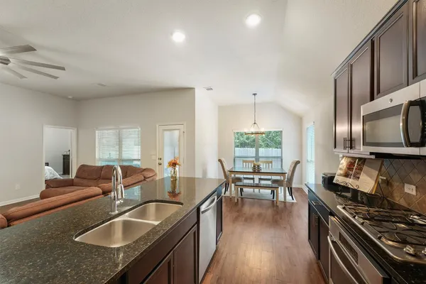 a kitchen with counter top space a sink and appliances