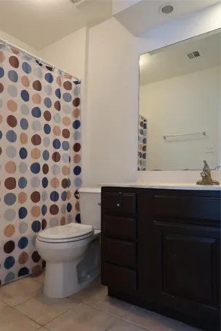 a white toilet sitting next to a white sink and vanity