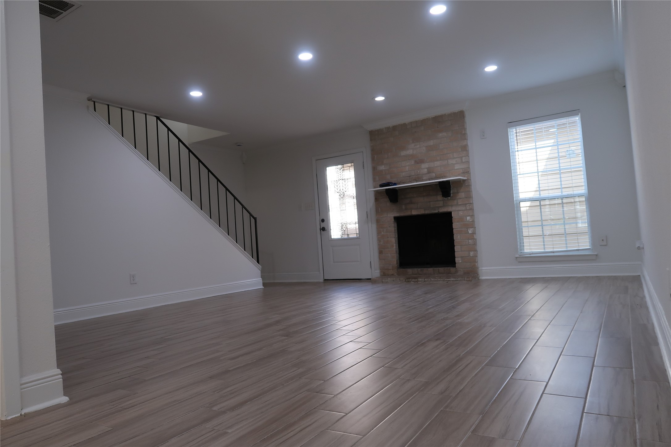 14209 Briarsage Court, Unit TH15 Houston, TX 77077 - Photo 3 of 31 an empty room with wooden floor fireplace and windows