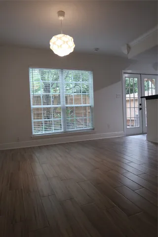 an empty room with wooden floor and entrance