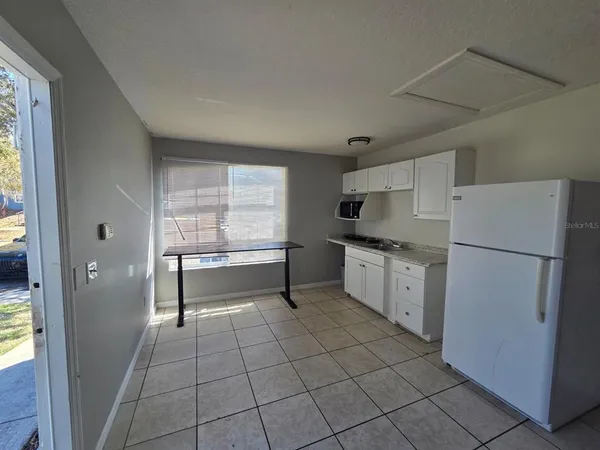 a kitchen with a refrigerator and white cabinets