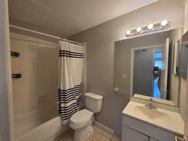a bathroom with a sink a toilet a mirror and shower