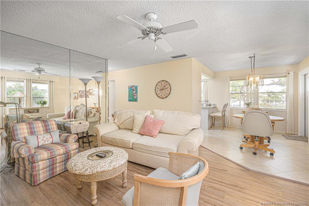 2929 Southeast Ocean Boulevard, Unit 1436 Stuart, FL 34996 - Photo 4 of 18 a living room with furniture and a large window with wooden floor