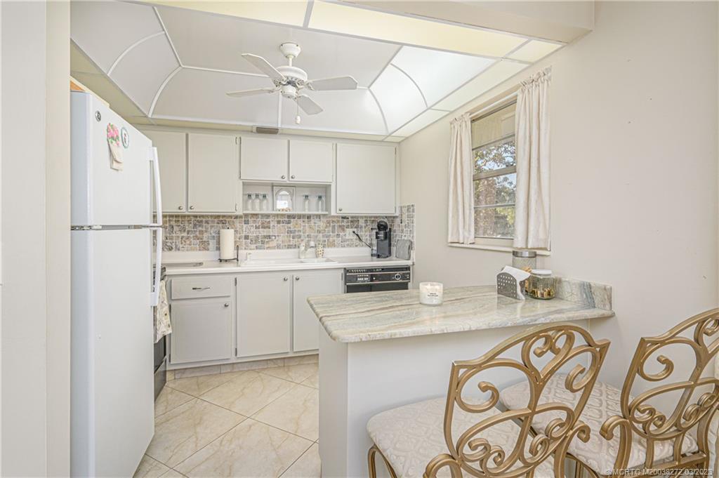 2929 Southeast Ocean Boulevard, Unit 1436 Stuart, FL 34996 - Photo 6 of 18 a kitchen with stainless steel appliances granite countertop a sink stove and refrigerator